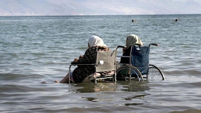 Palestinian women in wheelchairs take the waters of the Dead Sea. Menahem Kahana / AFP