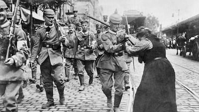 Prussian soldiers leaving Berlin for the front are given flowers by a woman.