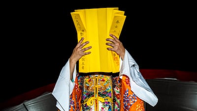 A Taoist priest raises a folded text during a crucial stage of the nocturnal Absolution Horse Ritual, meant to pardon wandering spirits, in Yunlin, Taiwan. Getty Images
