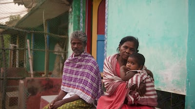 Jaya Rajamma sitting outside her house with a relative and her granddaughter. She says that she loved the sea as a child but is now scared of it and avoids looking at it at night.