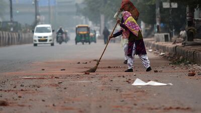 A man sweeps a road after the previous day's protest against the India's new citizenship law in New Delhi. AFP
