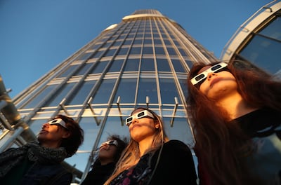 Residents wearing special glasses as they watch a partial solar eclipse in Dubai last year. EPA