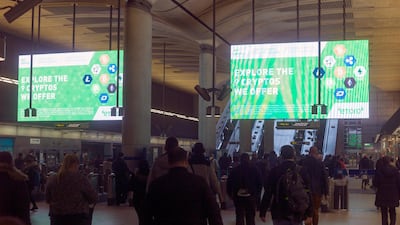 Giant electronic billboards display adverts for crypto currency investment companies at Canary Wharf tube station in London. Trading in digital currencies had halved. Simon Walker/Reuters