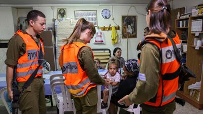 Israeli soldiers from Home Front Command visit families inside a bomb shelter in the southern Israeli city of Ashkelon, on May 18, 2021, following rocket attacks fired from the Gaza Strip. AFP