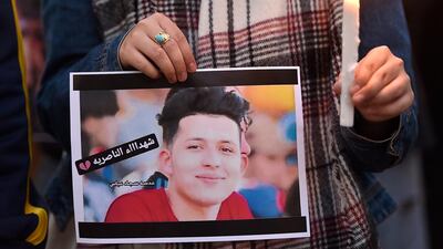A Lebanese activist carries a candle and a picture for an Iraqi child who died during the uprising in Iraq during a gathering to support the children in the uprising in Iraq in front of the Iraqi embassy in Beirut. EPA