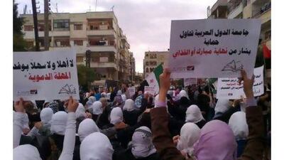 Demonstrators stage a protest against the Syrian president Bashar Al Assad in Homs on Sunday.