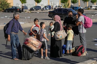 Families carry their belongings in Beirut's Martyrs' square after fleeing the Israeli airstrikes in the southern suburbs of Dahiyeh, Saturday, Sept. 28, 2024. (AP Photo / Bilal Hussein)