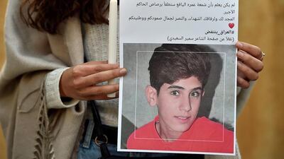 A Lebanese activist carries a candle and a picture for an Iraqi child who died during the uprising in Iraq during a gathering to support the children in the uprising in Iraq in front of the Iraqi embassy in Beirut. EPA