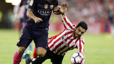 Athletic Bilbao defender Eneko Boveda, right, fights for the ball with Barcelona striker Luis Suarez. Miguel Tona / EPA