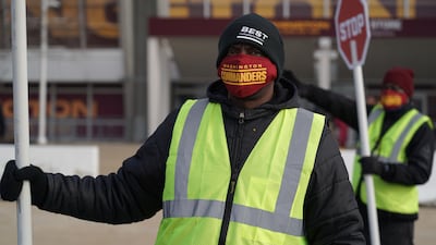 A traffic guard wears a Washington Commanders face mask outside of Fedex Field. Willy Lowry / The National.