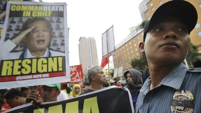 A Philippine policeman wears a black tape on his badge as a gesture of sympathy to his comrades as he blocks protesters from reaching the US embassy in Manila, Philippines after a botched operation against Southeast Asia's top terrorist suspect Malaysian Zulkifli bin Hir, that resulted in the death of 44 police commandos. AP Photo/Aaron Favila