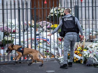 A police officer in Nice, France, inspects flowers in front of Notre Dame basilica, before a mass to pay tribute to terrorist attack victims on November 1, 2020 in Nice, France. Getty
