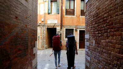 Backpackers are seen in a street in Venice, Italy. Reuters