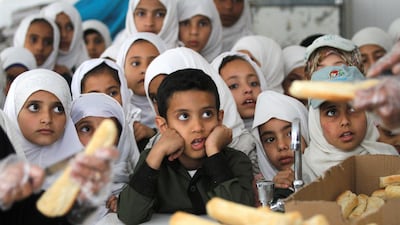 Yemeni students wait to get free food from a local charity at a school in Yemen. REUTERS