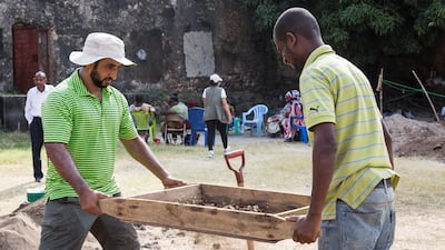 An archaeologist with Abu Dhabi's Tourism and Culture Authority, Omar Al Kaabi sieves for finds with a local member of the excavation team in Stone Town, Zanzibar.