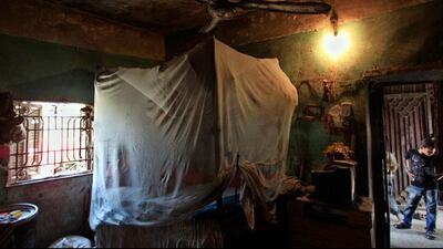 A boy stands outside one of two bedrooms in a house of Palestinian refugee Khadra Mohammed, 52, where she lives with 19 people in Gezirat al-Fadel village, Sharqiya.