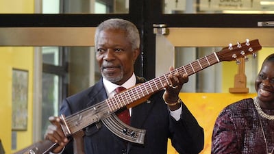Former UN Secretary-General Kofi Annan shows an AK-47 assault rifle that has been transformed into a guitar in front of workers at Vienna's United Nations headquarters. Annan was guest of honour at the naming ceremony of the Kofi Annan Building. - Former United Nations Secretary General and Nobel Peace Prize laureate Kofi Annan has died on August 18, 2018 after a short illness at the age of 80. (Photo by SAMUEL KUBANI / AFP)