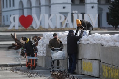 People set up a barrier of sandbags in downtown Kyiv on March 11. The UN refugee agency says over 2.5 million people have left Ukraine since the invasion began on February 24. But many have decided to stay. EPA