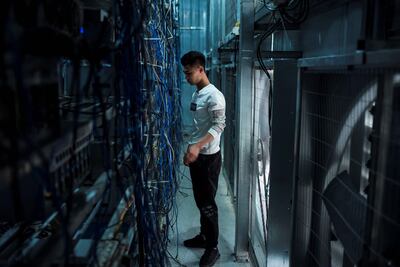 A worker adjusting cryptocurrency mining rigs at a cryptocurrency farm in Dujiangyan in China's south-western Sichuan province. AFP