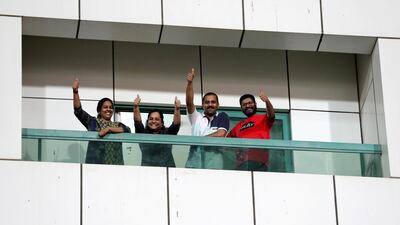 Cricket fans wait on their balcony of their apartment outside Sharjah Cricket Stadium during an IPL match.