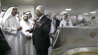 Saqr Ghobash, left, Minister of Labour, talks with Hisham Sidani, operations manager for the ICAD Workers’ Village in Mussaffah, as he inspects the kitchen, residential, sports and service facilities. Silvia Razgova / The National