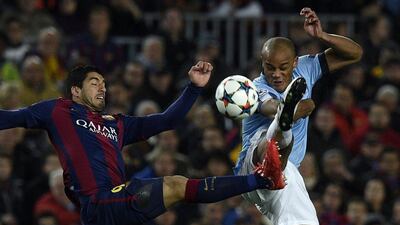 Barcelona's Luis Suarez and Manchester City's Vincent Kompany vie for the ball on Wednesday night during their Champions League contest. Lluis Gene / AFP