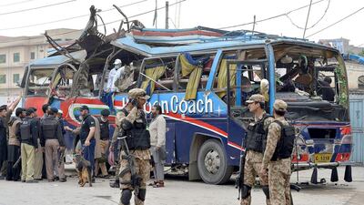 Pakistani security officials inspect a damaged bus after a bomb blast in Peshawar on March 16, 2016. A Majeed / AFP