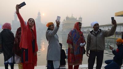 Indian devotees take selfies at the Golden temple in Amritsar. Narinder Nanu / AFP Photo