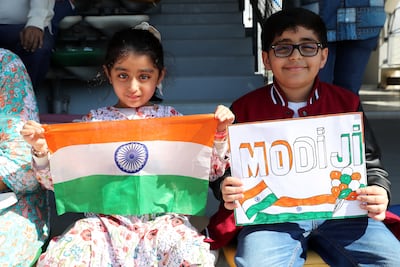 Visitors during the Ahlan Modi event held up signs to support Indian Prime Minister Narendra Modi. Pawan Singh / The National