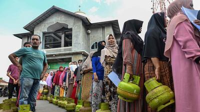 Indonesians queue to buy subsidised liquefied petroleum gas for cooking in Lambaro, Aceh province. AFP