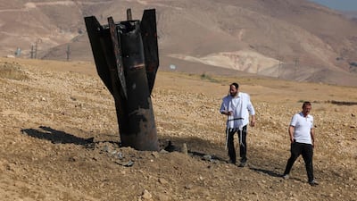 Two men examine a fallen rocket on the outskirts of Jericho in the occupied West Bank on Monday following Iranian and Iran-backed Houthi rebel attacks. AFP