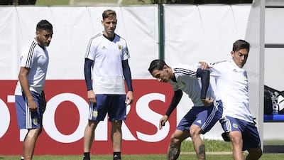 Angel Di Maria, second right, and forward Paulo Dybala tussle for the ball. Juan Mabromata / AFP