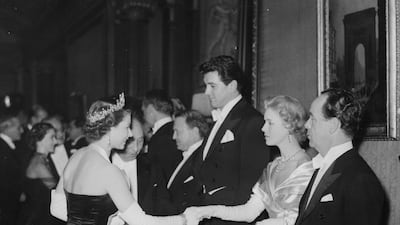 She meets actress Veronica Hurst and actor Rock Hudson at the Royal Film Performance in London in 1952. Getty