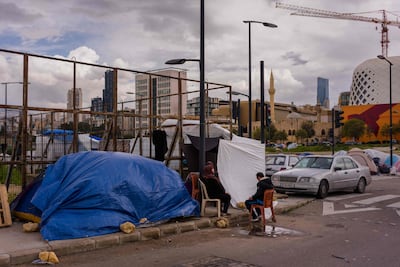 A displaced family sits next a makeshift tent in an unofficial camp, erected along Beirut’s seafront area on March 22, 2026. AFP