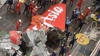 Rescuers wave at an Indonesian Air Force helicopter near portion of AirAsia Flight 8501 after it was recovered from the sea floor on the deck of a rescue ship on the Java Sea on Januar 10. AP Photo