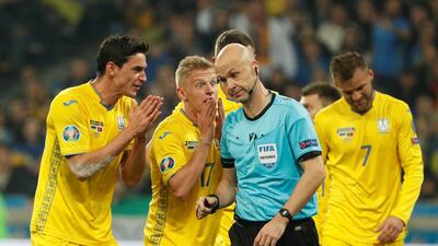 Soccer Football - Euro 2020 Qualifier - Group B - Ukraine v Portugal - NSC Olympiyskiy, Kiev, Ukraine - October 14, 2019 Ukraine's Roman Yaremchuk and Oleksandr Zinchenko remonstrate with referee Anthony Taylor after Ukraine's Taras Stepanenko is shown a red card REUTERS/Valentyn Ogirenko