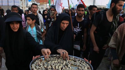 Shiite Muslim pilgrims help themselves to a snack as they walk in the holy Iraqi city of Karbala. AFP