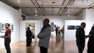 Visitors look on artworks at the student-curated exhibition at The Project Space--NYUAD’s auxiliary gallery at the Art Centre.