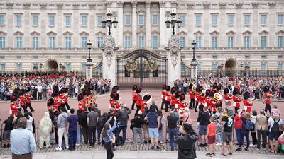 Members of the public watch the Band of the Coldstream Guards marching during the Changing the Guard ceremony at Buckingham Palace in London. PA