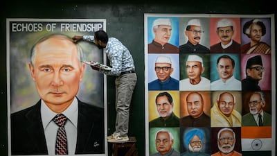 An artist adds the final touches to a painting of Russia's President Vladimir Putin, next to portraits of Indian Prime Minister Narendra Modi and his predecessors, before Mr Putin's visit to the country. AFP