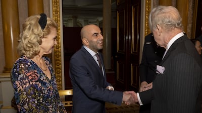 King Charles, right, greets train guard Samir Zitouni and wife Eleni Sakkoulei at Buckingham Palace in London. Getty Images