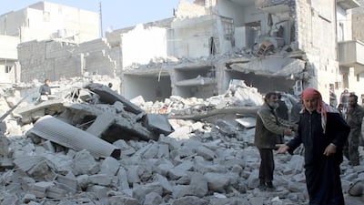 Civilians stand on a damaged street in Aleppo after government forces allegedly shelled the northern city on Saturday. Zein Al Rifai / AFP