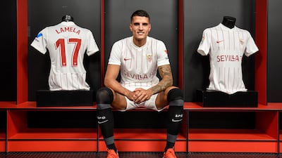 Erik Lamela sits next to a Sevilla shirt with his name on at the club's Sanchez Pizjuan Stadium in Seville.