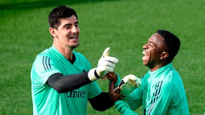 Real Madrid's Belgian goalkeeper Thibaut Courtois jokes with Brazilian forward Vinicius Junior. AFP
