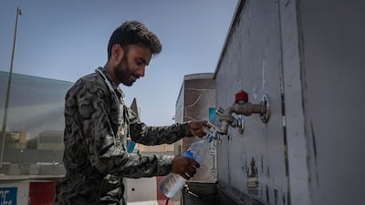 A Dubai resident fills a water bottle in Jumeirah, as UAE authorities take further steps to help people cope with high temperatures. Antonie Robertson / The National