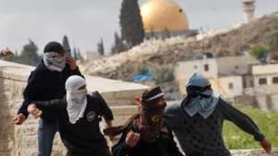 Palestinian demonstrators hurl stones at Israeli troops in East Jerusalem yesterday.