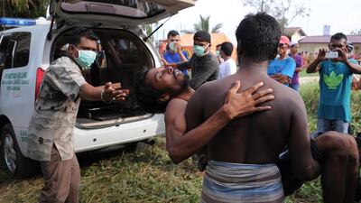A rescued migrant is carried to a waiting ambulance upon his arrival at the new confinement area in the fishing town of Kuala Langsa in Aceh province on May 15, where hundreds of migrants from Myanmar and Bangladesh - mostly Rohingyas - are taking shelter after they were rescued. Chaideer Mahyuddin/AFP Photo