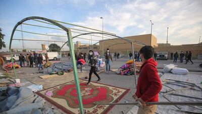 Supporters and members of Iraq's Hashed al-Shaabi paramilitary force dismantle their tents as they prepare to withdraw from the US embassy perimeter. AFP