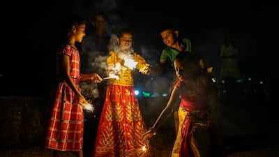 Children light the fireworks in Mumbai. AP