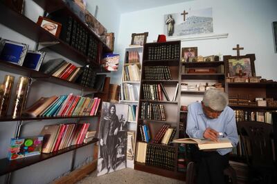 George Zaarour, a specialist in the Aramic language, reads a book written in the Aramic, at his shop in the Syrian mountain village of Maalula. AFP